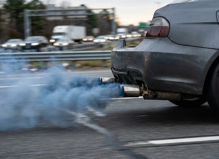 Technician checking vehicle symptoms of blue smoke: worn piston rings vs. valve seals symptoms in the engine oil control and combustion system
