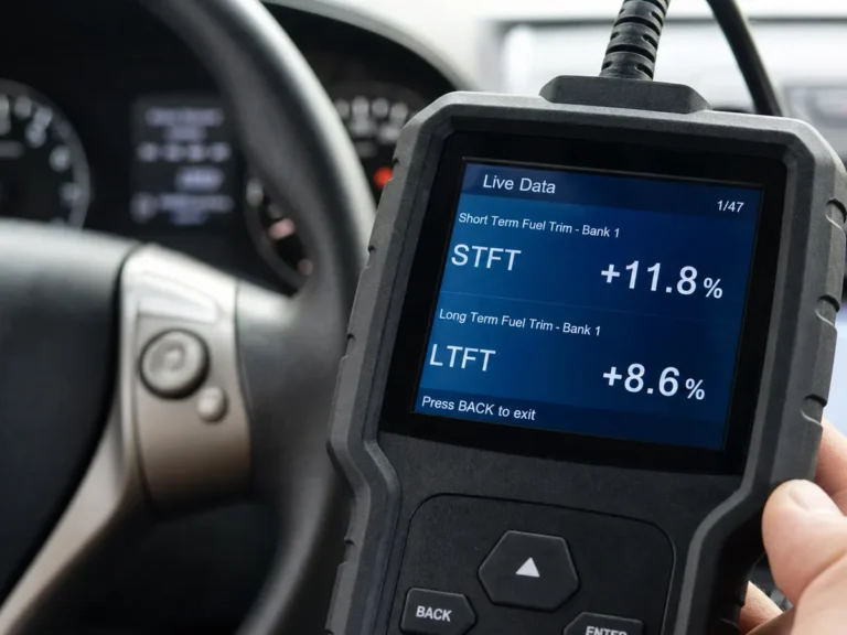 Mechanic using OBD-II scanner to read fuel trim data for a car with no check engine light illuminated